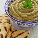 Turkish dips eggplant served in a traditional bowl with grilled flatbread on a rustic table